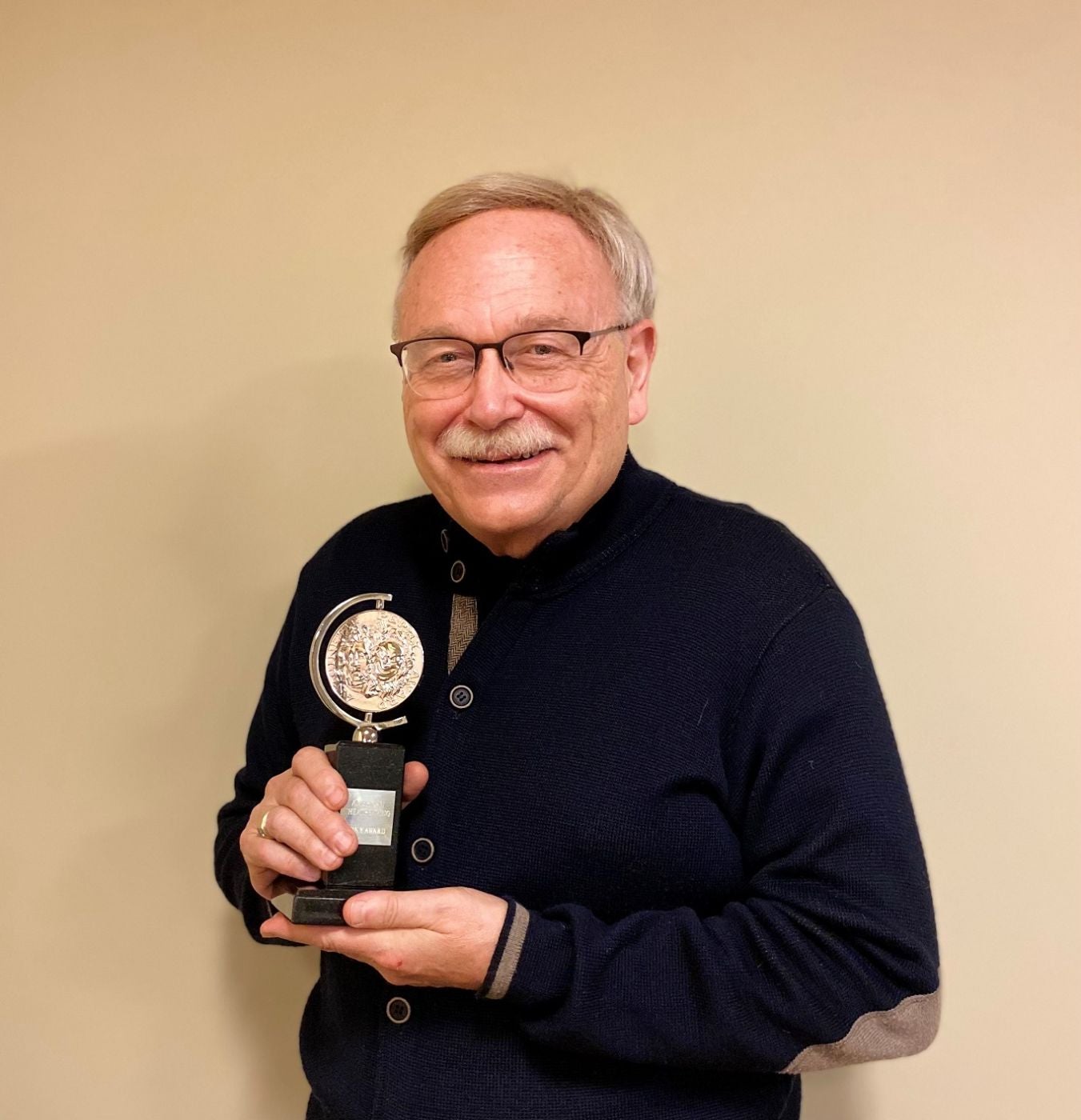 A photo of PPAC President and CEO holding the Tony Award 